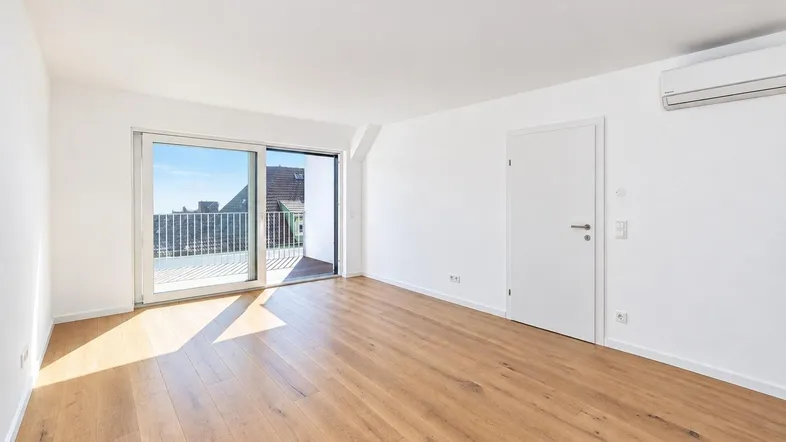 Heller Wohnraum mit Holzboden, Klimaanlage und großem Schiebefenster zu einem Außenbereich.