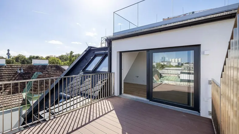 Sonnige Dachterrasse mit modernem Geländer und weitem Blick über die Stadt.