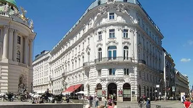 Historisches Gebäude mit klassischer Architektur und belebter Straße in der Stadt.