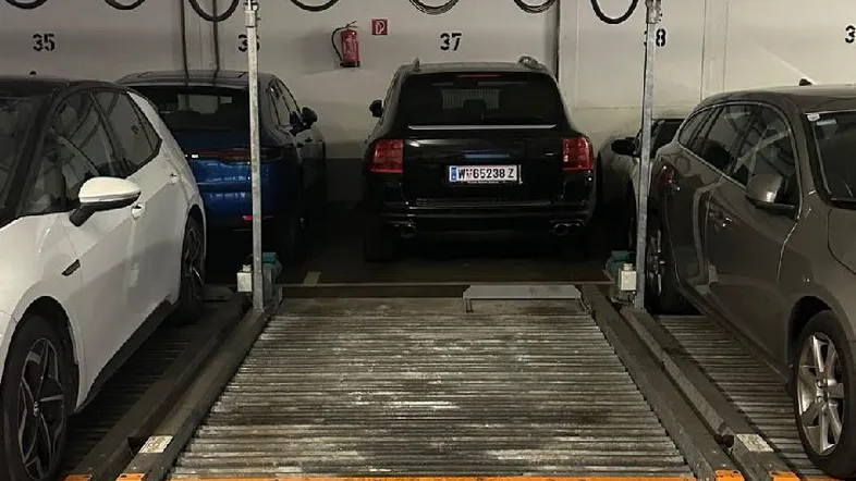 Tiefgarage mit mechanischem Parksystem und mehreren Fahrzeugen auf den Stellplätzen.