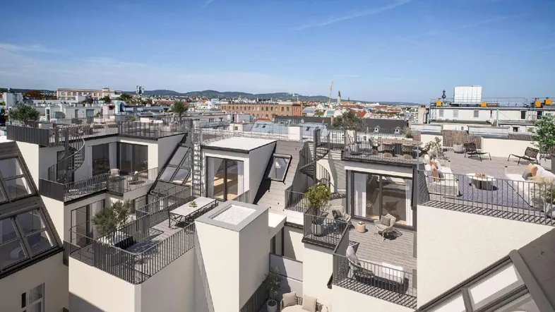 Luftaufnahme eines Gebäudekomplexes mit mehreren Dachterrassen und Balkonen.