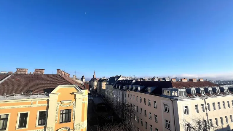 Blick über die Dächer der Stadt mit historischen Gebäuden unter blauem Himmel.