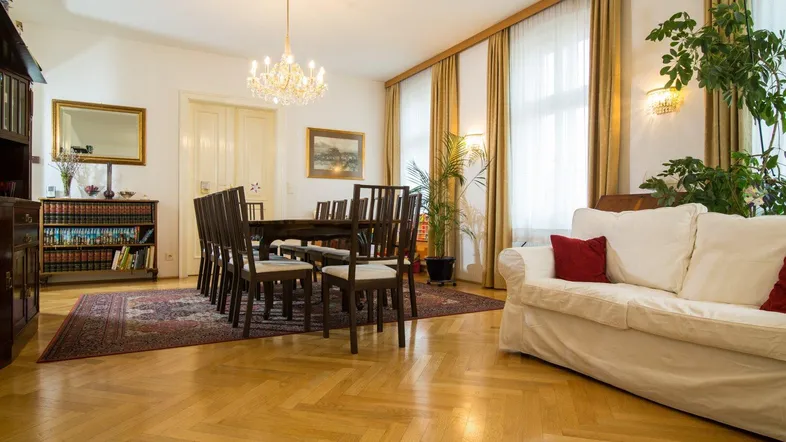 Geräumiger Wohn-Essbereich mit elegantem Esstisch, bequemer Couch und hellem Parkettboden.