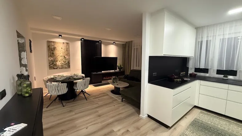 Offener Wohn- und Essbereich mit integrierter Küche, modernem Design und hellem Boden.