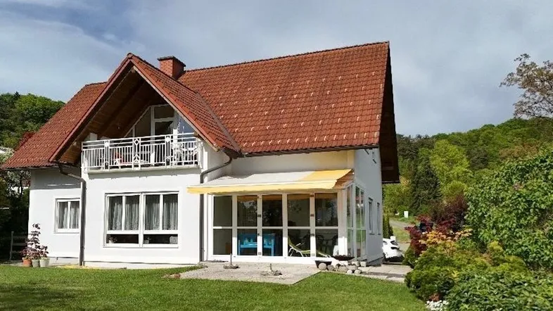 Freistehendes Einfamilienhaus mit großem Garten, Balkon und Wintergarten in ländlicher Umgebung.