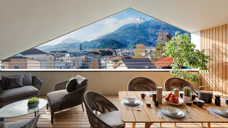 Geräumige Terrasse mit Ess- und Loungebereich, Holzboden und beeindruckendem Bergblick.