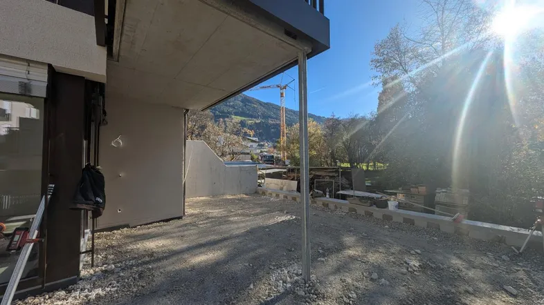Baustelle im Außenbereich eines neuen Gebäudes mit Blick auf die Berge und die Sonne.