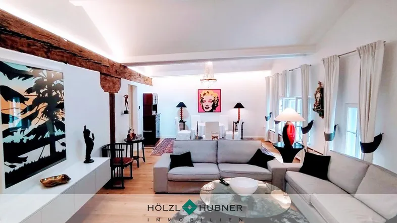Geräumiger Wohn- und Essbereich mit Holzbalken, Kronleuchter und moderner Einrichtung.