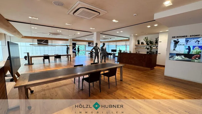 Großer, offener Verkaufsraum mit Holzboden, modernen Tischen und großen Schaufenstern.