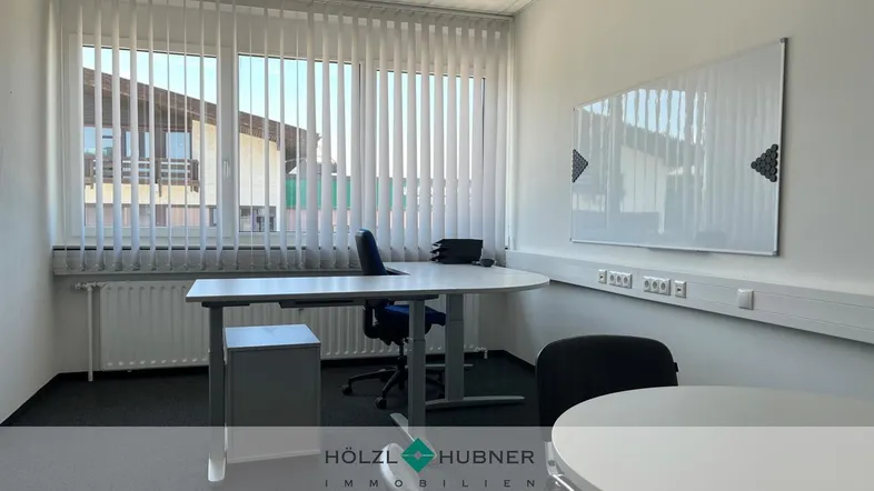 Helles Büro mit großen Fenstern, vertikalen Jalousien und moderner Einrichtung, ideal für produktives Arbeiten.