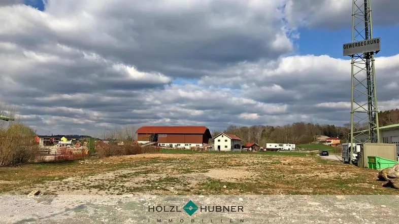 Weitläufiges Gewerbegrundstück mit Blick auf umliegende Gebäude und bewölktem Himmel, ideal für neue Projekte.