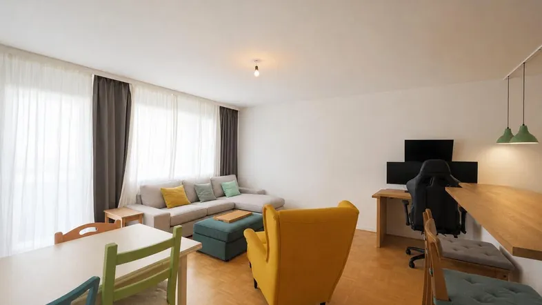 Helles, offenes Wohn- und Esszimmer mit Parkettboden und modernem Mobiliar.