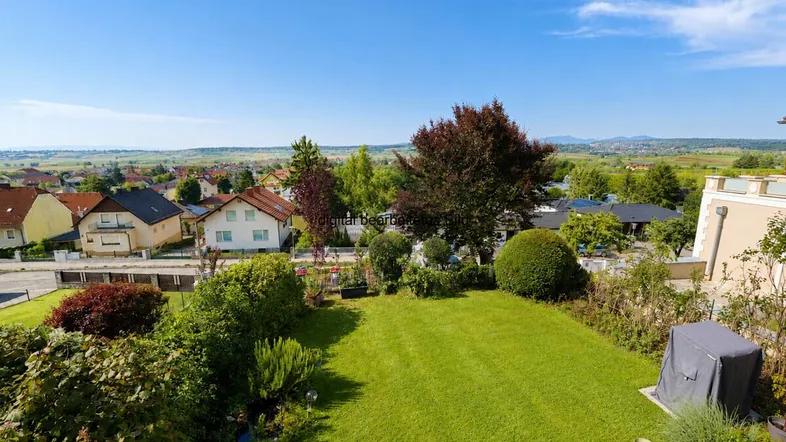 Gepflegter Garten mit Rasenfläche und weitem Blick über die umliegende Landschaft.