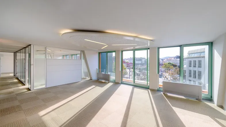 Geräumiges, helles Büro mit großen Fenstern und Blick auf die Stadt, ausgestattet mit Teppichfliesen.