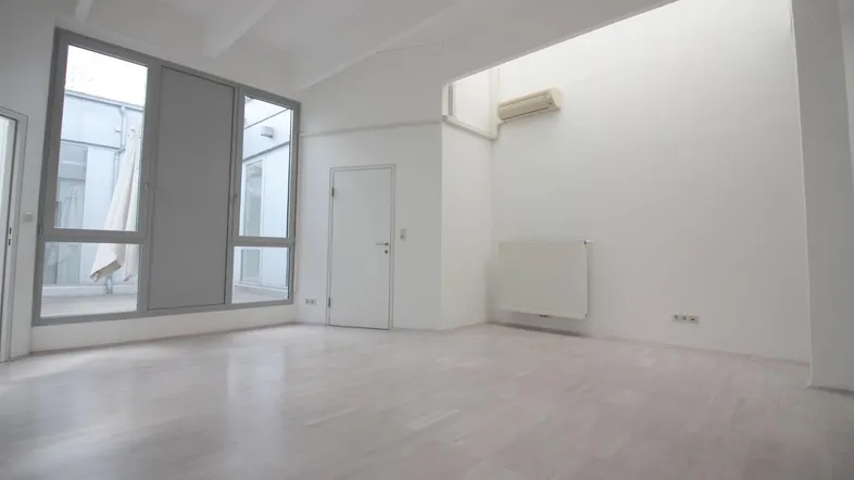 Heller, leerer Büroraum mit großen Fenstern, hohen Decken und Klimaanlage, ideal für flexible Nutzung.