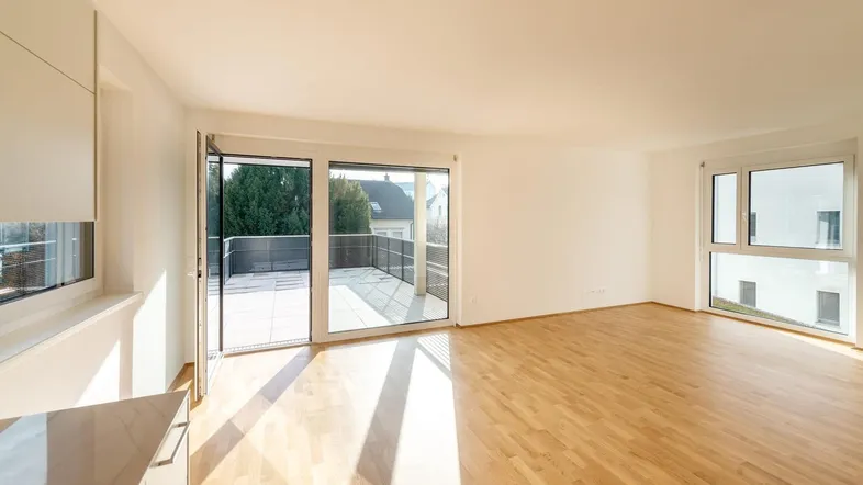 Heller, offener Wohnbereich mit Holzboden und direktem Zugang zur sonnigen Terrasse.