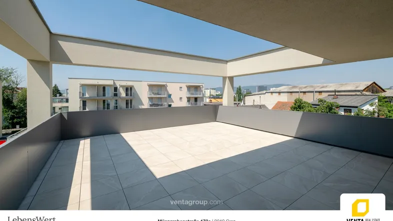 Geräumige Dachterrasse mit hellen Fliesen und Blick auf die umliegenden Gebäude.