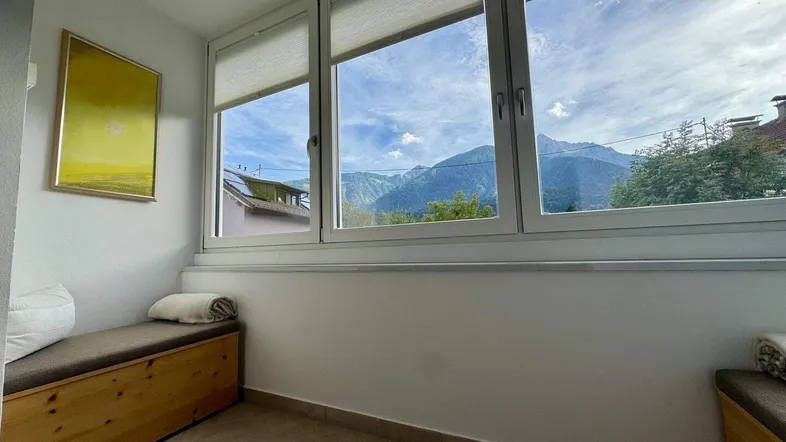 Gemütlicher Sitzbereich mit großen Fenstern und beeindruckendem Bergblick.