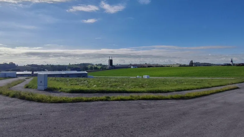 Weite grüne Landschaft mit Feldern und einem klaren blauen Himmel, ideal für Naturliebhaber.