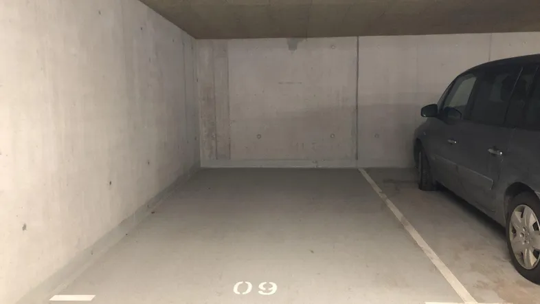 Tiefgaragenstellplatz Nummer 09 mit Betonwänden und -decke, bietet sicheren Parkraum.