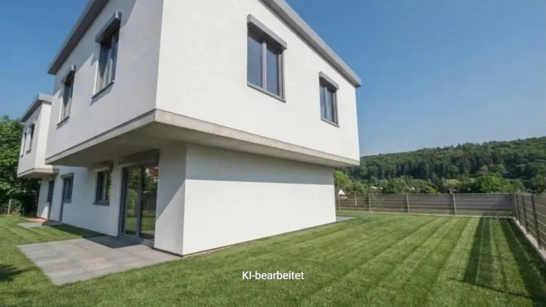 Moderne weiße Fassade eines Neubaus mit gepflegtem Rasen und blauer Himmel.