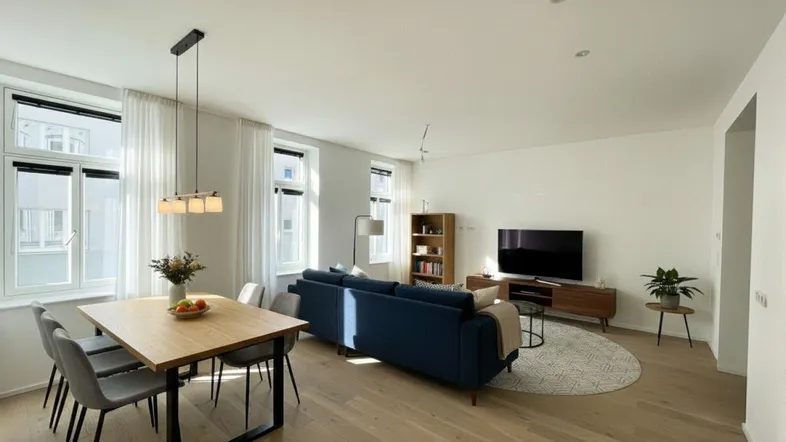 Helles, modern eingerichtetes Wohn-Esszimmer mit Holzboden und großen Fenstern.