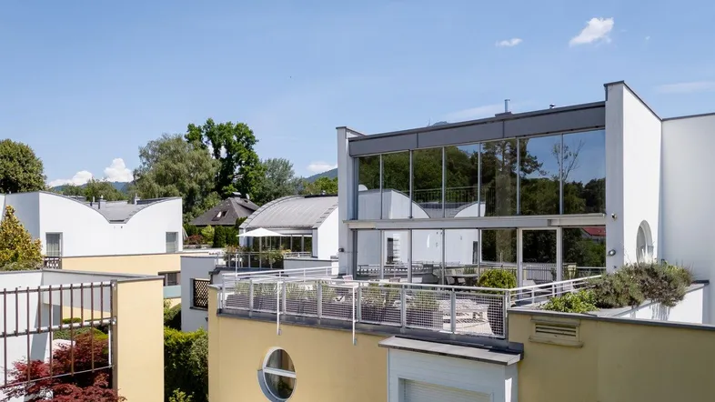 Moderne Architektur mit großen Glasflächen und Flachdächern in einer Wohnanlage.