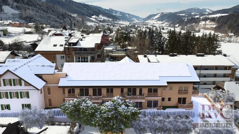 Renderte Luftaufnahme eines modernen Gebäudekomplexes in verschneiter Berglandschaft.