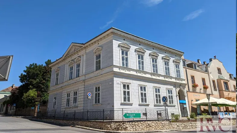 Historisches Gebäude an einer Straßenecke mit klassischer Architektur und hellblauer Fassade.