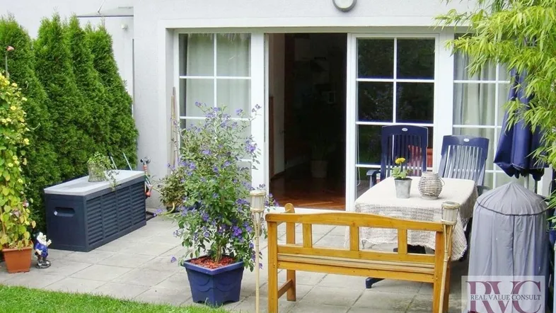 Gepflasterte Terrasse mit Gartenmöbeln und direktem Zugang zum Wohnbereich und Garten.