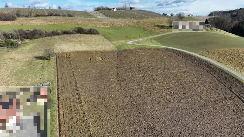 Luftaufnahme eines weitläufigen Grundstücks mit Ackerland, grünen Hügeln und einer Landstraße in ländlicher Umgebung.