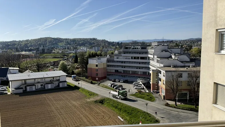 Weitläufiger Blick über die Stadt und die umliegende Landschaft von einem oberen Stockwerk.