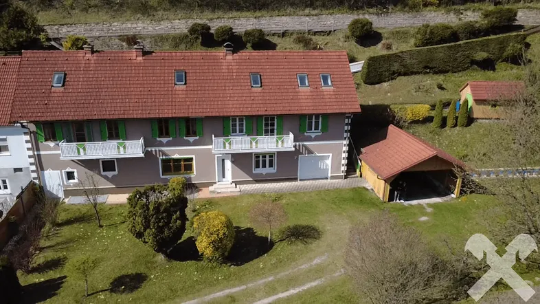 Luftaufnahme des Hauses mit rotem Ziegeldach, Garten und Carport in ländlicher Umgebung.