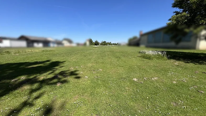 Weitläufige grüne Wiese unter blauem Himmel, ideal für ein neues Bauprojekt oder als Gartenfläche.