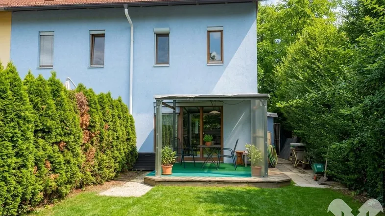 Gepflegter Gartenbereich mit Rasenfläche und überdachtem Sitzplatz hinter dem Haus.
