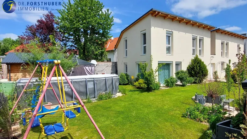 Gepflegter Gartenbereich mit oberirdischem Pool, Schaukel und Rasenfläche vor dem modernen Haus.