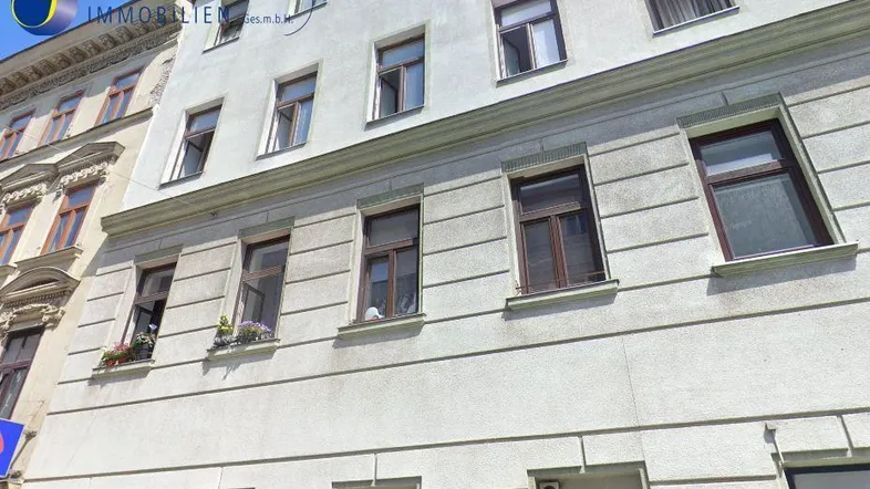 Fassade eines Mehrfamilienhauses mit mehreren Fenstern und klassischer Architektur.