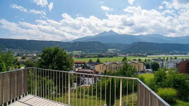 Geräumiger Balkon mit Fliesenboden und weitem Blick über die Stadt und die umliegenden Berge.