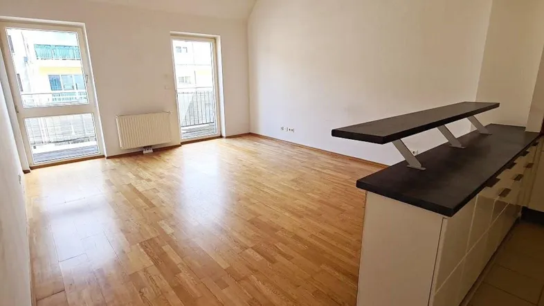 Helles Wohnzimmer mit Parkettboden und integrierter Theke, ideal für offenes Wohnen.