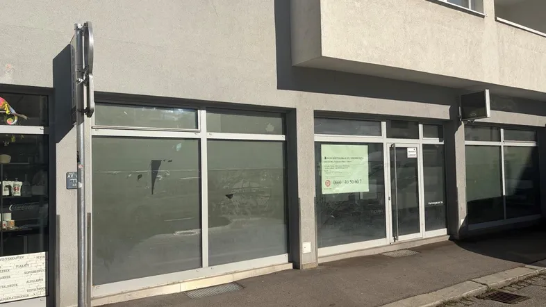 Außenansicht eines Geschäftsgebäudes mit großen Schaufenstern und einer modernen Fassade.