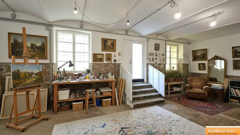 Geräumiges Künstleratelier mit hohen Decken, großen Fenstern und viel natürlichem Licht, ideal für kreative Arbeit.