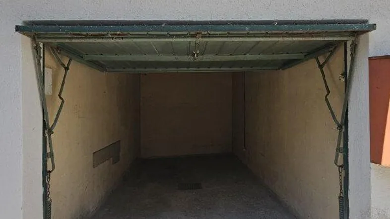 Offene Einzelgarage mit Betonboden und Blick in den leeren Innenraum, bereit zur Nutzung.