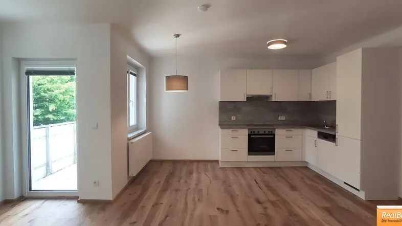 Wohnesszimmer mit Einbauküche und Ausgang zum Balkon