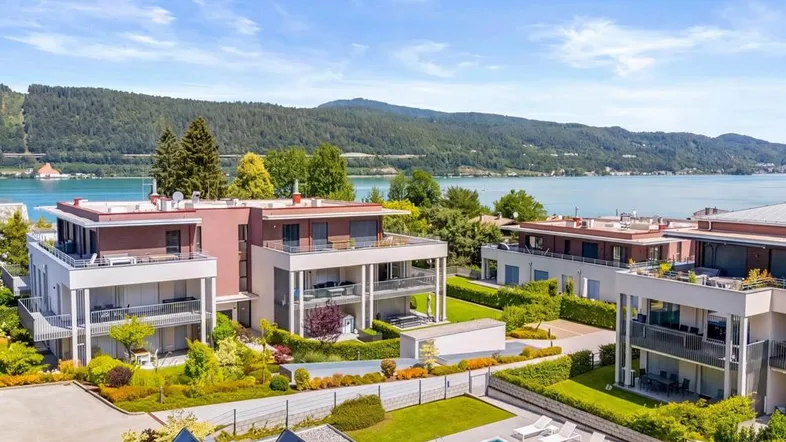 Luftaufnahme einer modernen Wohnanlage mit See- und Bergblick sowie Gemeinschaftspool.