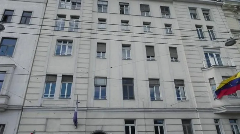 Mehrstöckiges Gebäude mit vielen Fenstern, Rollläden und Dachgauben, typisch für eine Stadtansicht.
