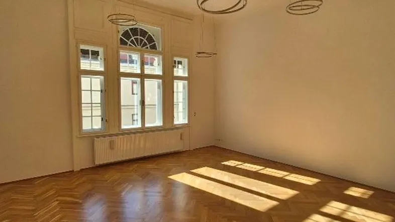 Heller Raum mit Fischgrätparkettboden und großen Fenstern, die viel Tageslicht hereinlassen und eine moderne Atmosphäre schaffen.