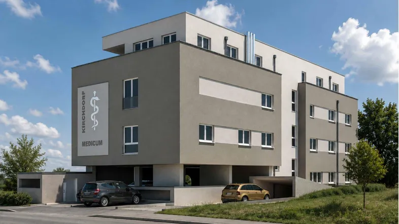 Modernes Gebäude mit zweifarbiger Fassade und Tiefgaragenzufahrt unter blauem Himmel.