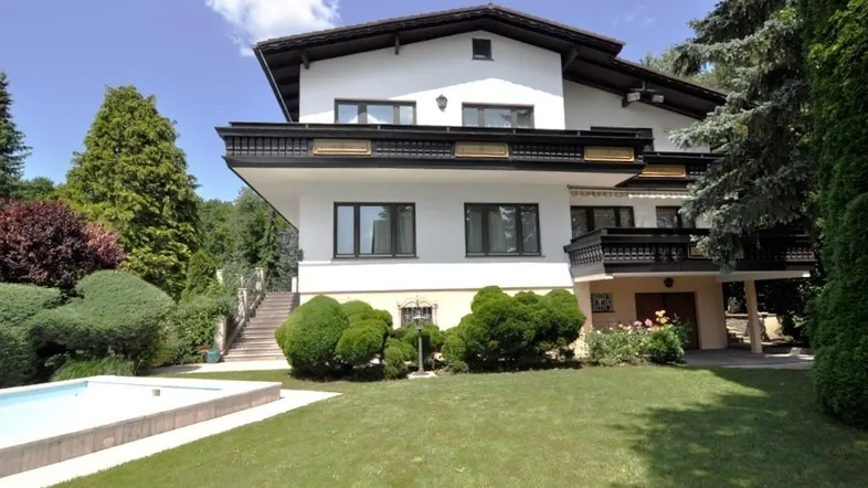 Großzügiges Anwesen mit weißer Fassade, gepflegtem Garten und einem erfrischenden Außenpool.