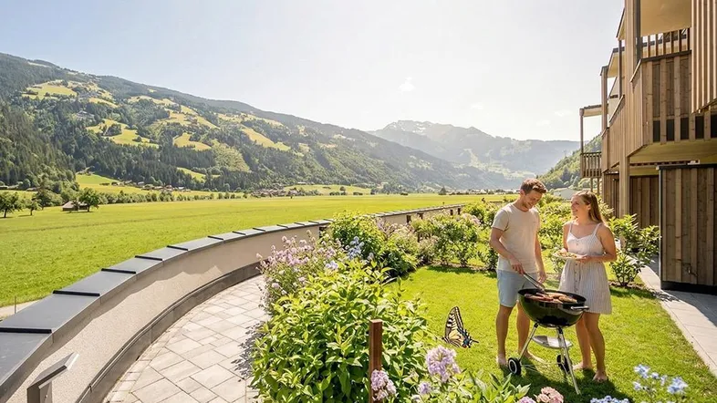 Gartenbereich mit Grillplatz und atemberaubendem Bergblick, ideal für entspannte Abende im Freien.
