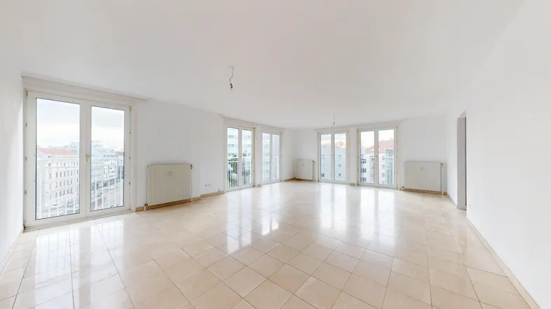 Helles, geräumiges Zimmer mit Fliesenboden und mehreren Fenstern mit Stadtblick.